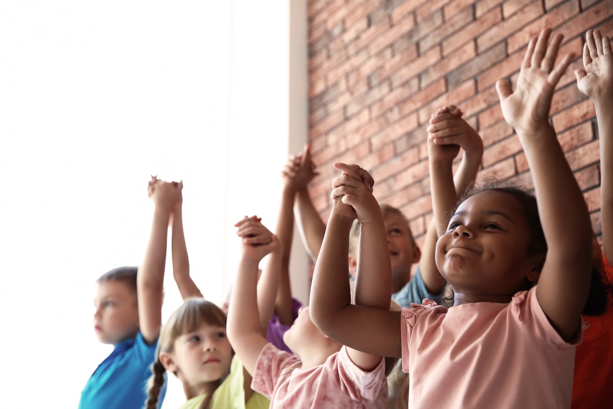 Children reaching upward together